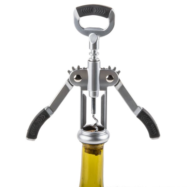 A Tablecraft Premium Winged Corkscrew opening a bottle with a cork.
