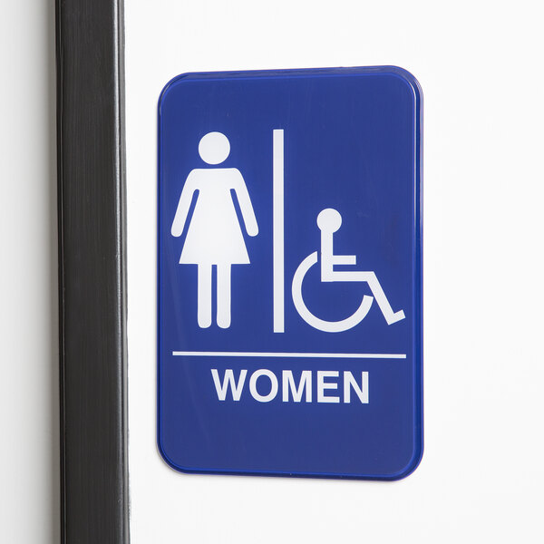 A white and blue sign with a woman and a wheelchair.
