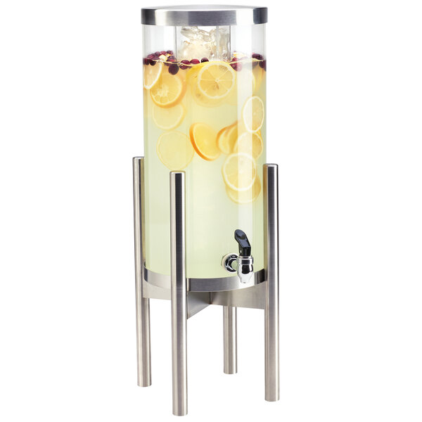 A Cal-Mil round glass beverage dispenser with lemons inside on a stainless steel base.