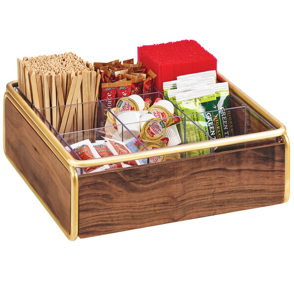 A Cal-Mil wooden condiment organizer with brass accents holding a variety of food items.