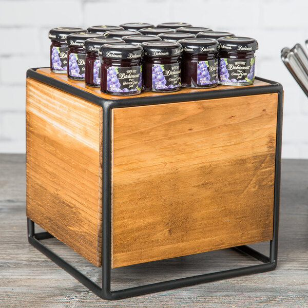 A group of jars of jam on a Cal-Mil Madera rustic pine square riser.