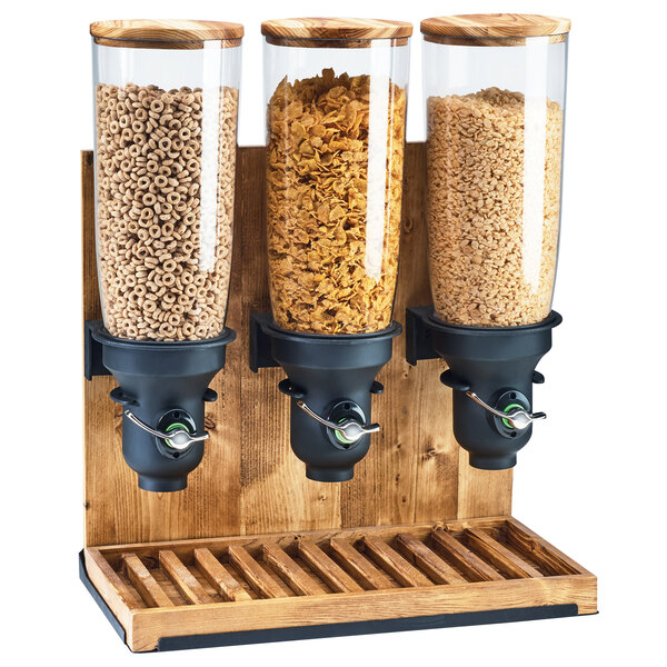 A Cal-Mil Madera triple cereal dispenser with glass jars full of cereal.
