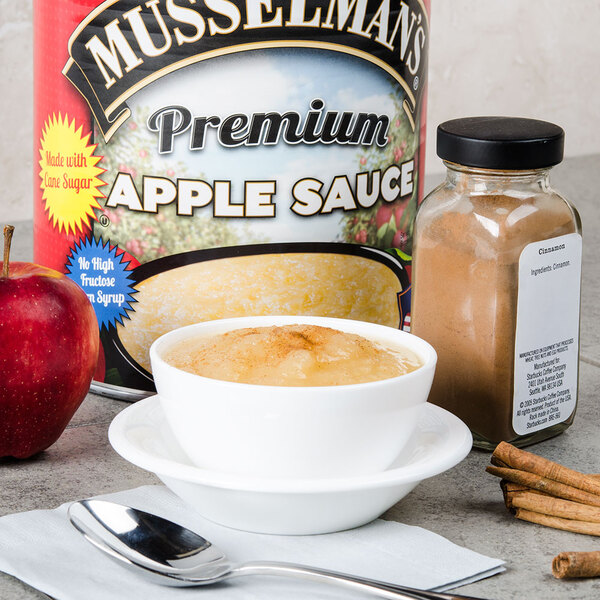 A bowl of Musselman's applesauce with cinnamon and a spoon.