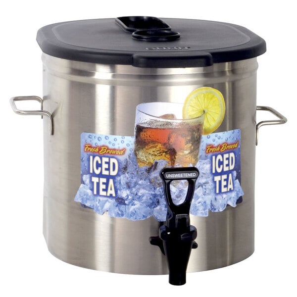 A Bunn stainless steel iced tea dispenser with a black lid on a table with a glass of iced tea and a lemon slice.