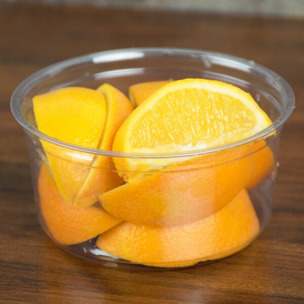 A Fabri-Kal clear plastic deli container filled with orange slices.