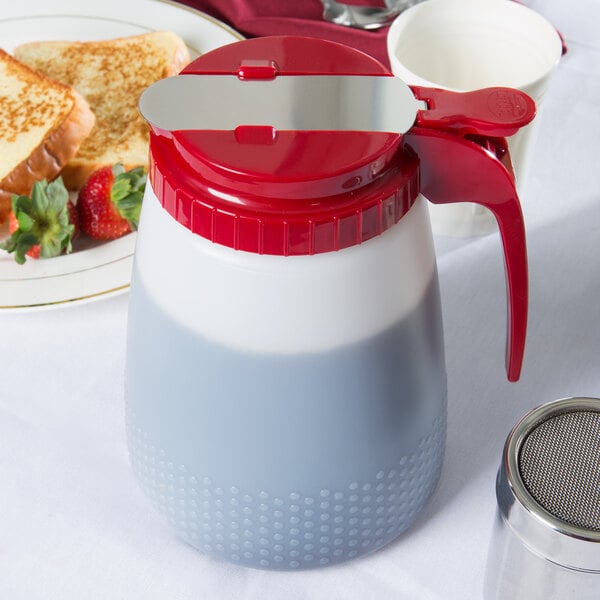 A Tablecraft red polyethylene dispenser with a red lid on a table with toast and strawberries.