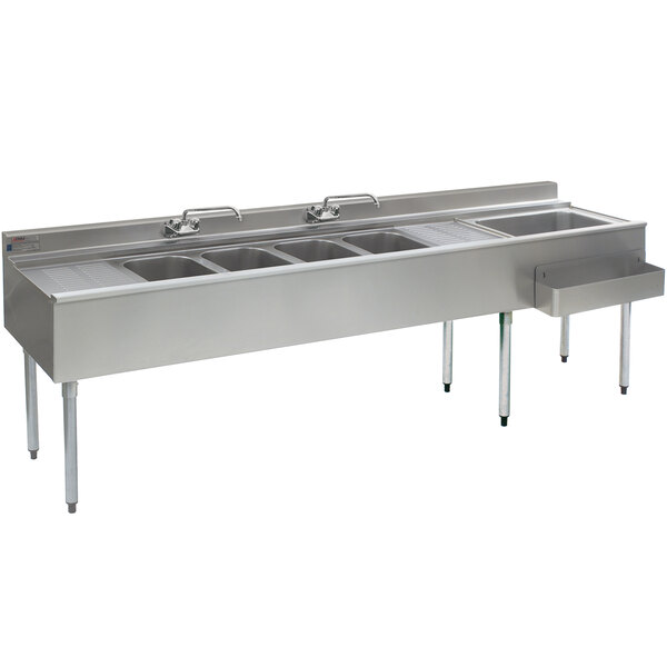 A stainless steel Eagle Group underbar sink with four compartments, two drainboards, and a right side ice bin.