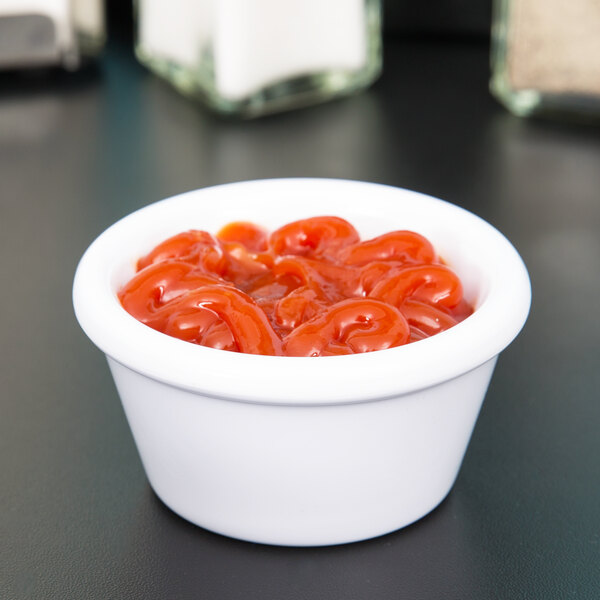 A white Carlisle ramekin filled with ketchup.