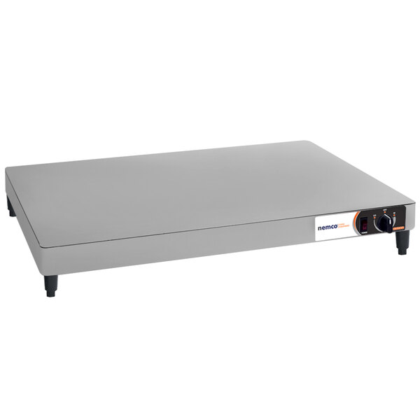 A rectangular stainless steel Nemco heated shelf warmer with a knob and button.