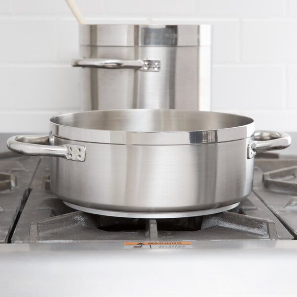 A stainless steel Vollrath Centurion brazier pan on a stove.