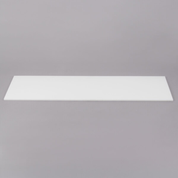 A white rectangular cutting board with a black border on a gray surface.