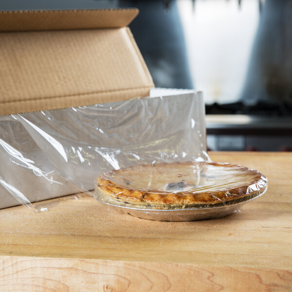 A pie in Berry perforated plastic wrap on a counter.