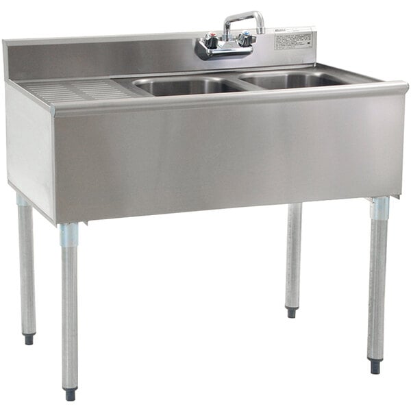 A stainless steel Eagle Group underbar sink with two bowls, a left drainboard, and a faucet.