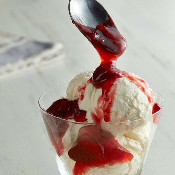 A scoop of I. Rice strawberry sundae topping over a bowl of ice cream.