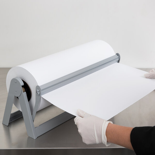 A person in gloves using a Bulman paper cutter to cut paper.