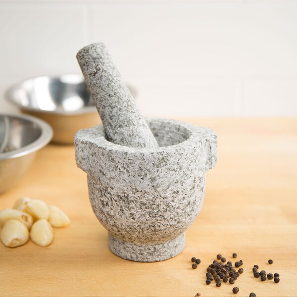 A Fox Run granite mortar and pestle with garlic and peppercorns.