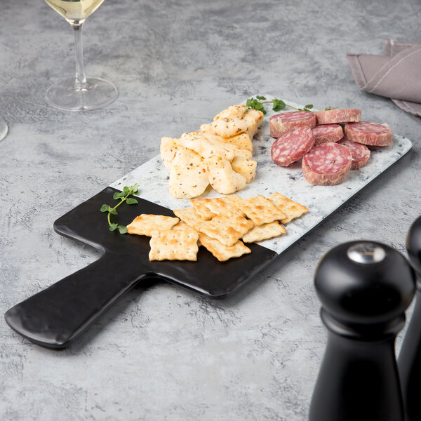 An Elite Global Solutions rectangular serving board with crackers on a table.
