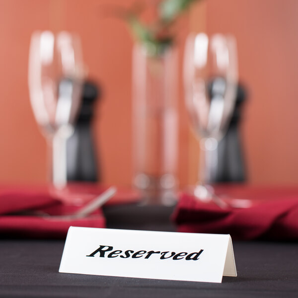 An American Metalcraft double-sided plastic table tent with a "Reserved" sign on a table.
