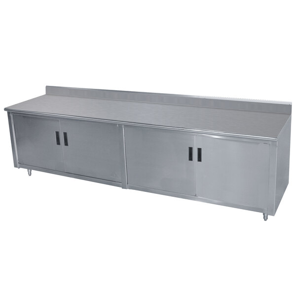 An Advance Tabco stainless steel work table with hinged doors and a backsplash.