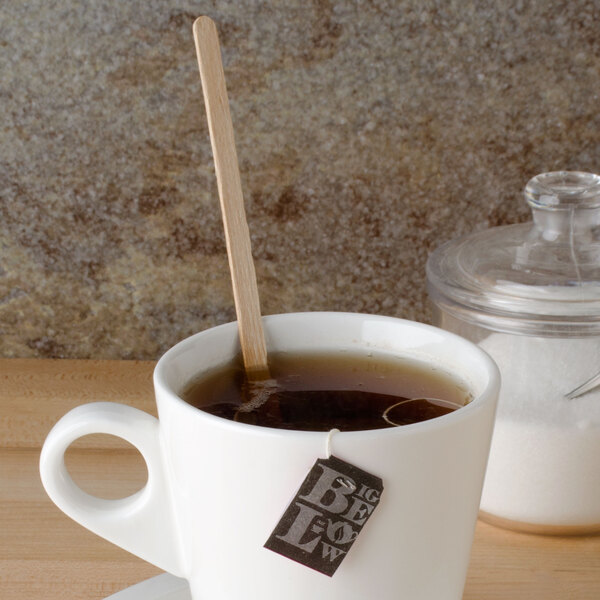 A cup of tea with a Royal Paper eco-friendly wooden stirrer in it.