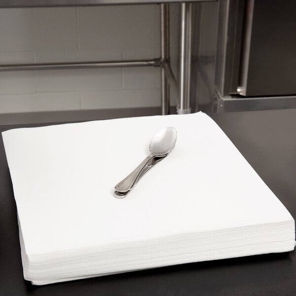 A stack of Hoffmaster white linen-feel paper napkins with a spoon on top.