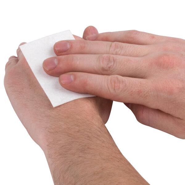 A person using a Medique non-adherent sterile pad to clean their hand.