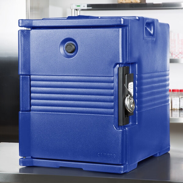 A navy blue plastic front loading food pan carrier with a lock.