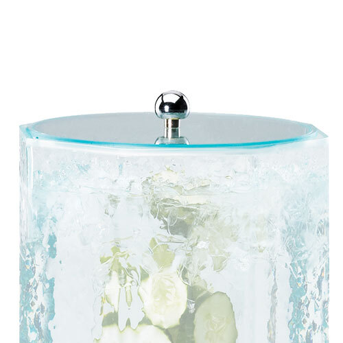 A Cal-Mil faux glass beverage dispenser lid on a glass container with ice and cucumbers.