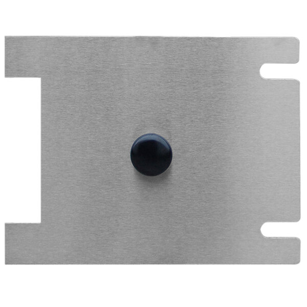 A metal plate with a white rectangular cover and a black circle.
