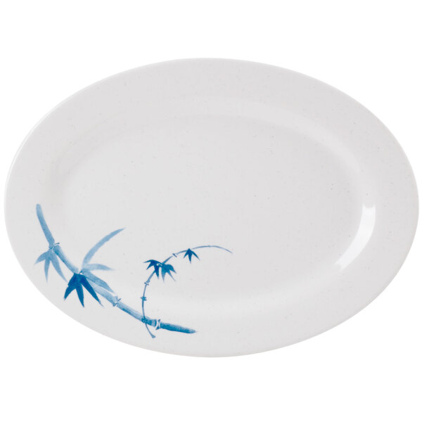 A white oval melamine platter with blue painted bamboo leaves.