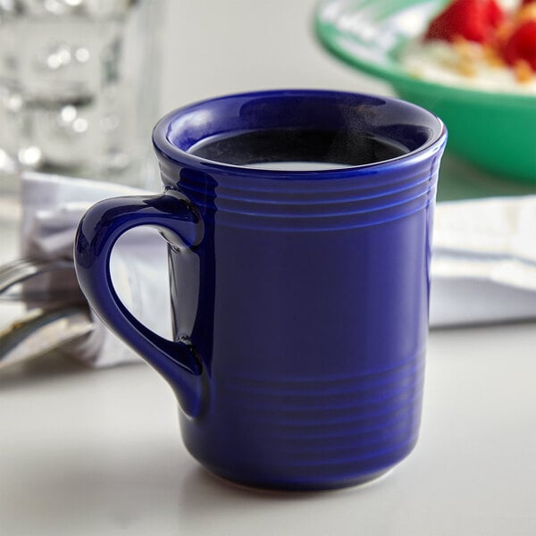 A close-up of a Tuxton Concentrix cobalt blue mug with liquid in it.