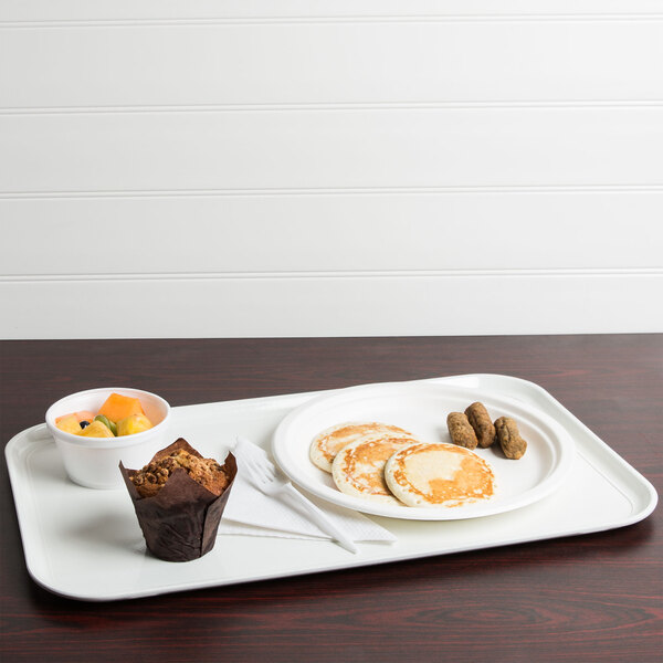 A white Cambro dietary tray with pancakes, fruit, and a muffin on it.