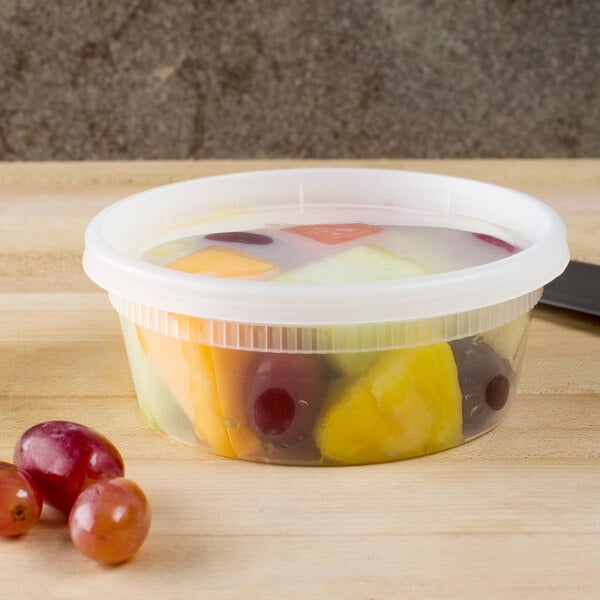 A plastic container of fruit on a table.