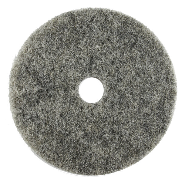 A grey circular Scrubble light burnishing floor pad with a hole in the middle.