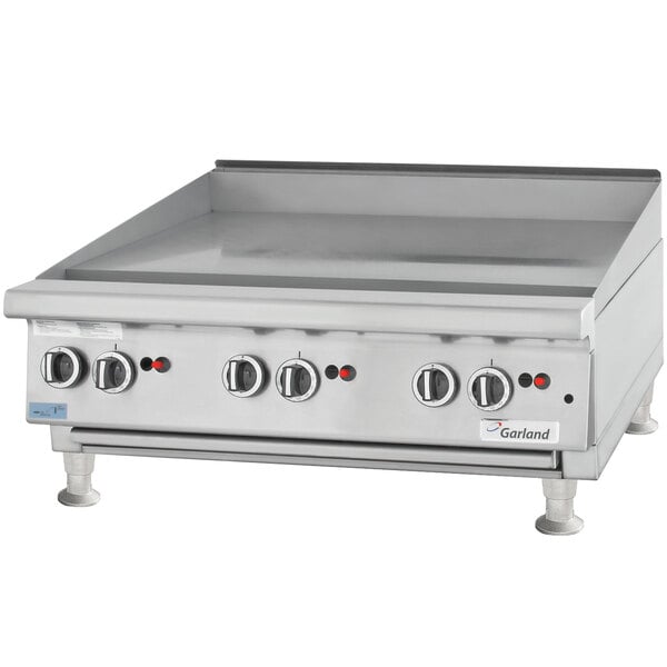 A Garland countertop gas griddle with manual controls.