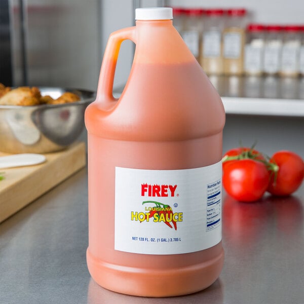 A gallon jug of Firey Louisiana hot sauce on a counter.