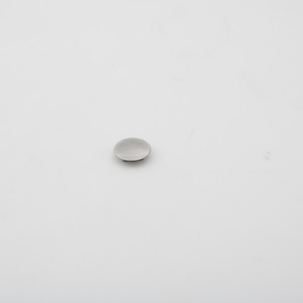 A round silver metal Norlake hole plug on a white surface.
