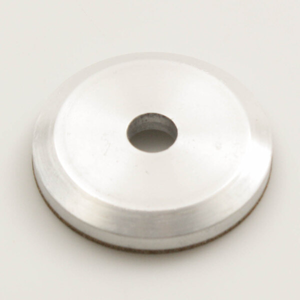 A round white metal disc with a hole in the center.