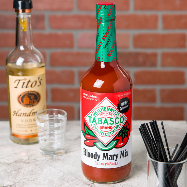 TABASCO Bloody Mary Mix on a table with a bottle of hot sauce and a glass.