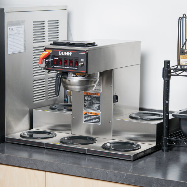 A Bunn automatic coffee machine with a stainless steel funnel on a counter.