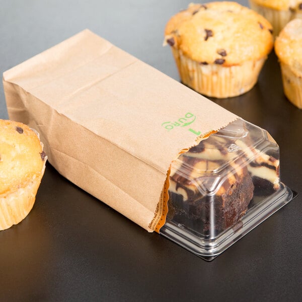 Two chocolate chip muffins in a Duro brown paper bag.