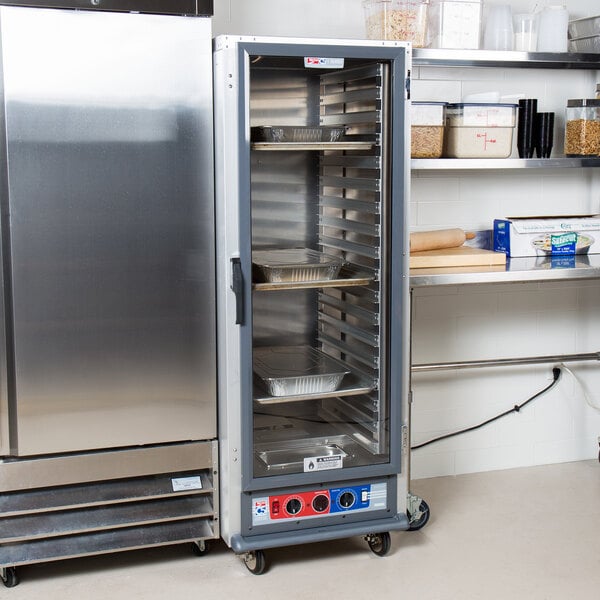A Metro C5 heated holding and proofing cabinet with trays on a shelf.