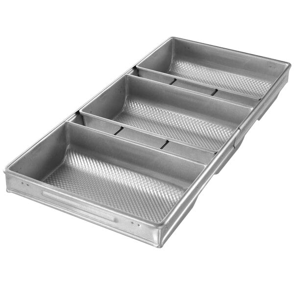 A silver Chicago Metallic bread pan with three rectangular compartments.