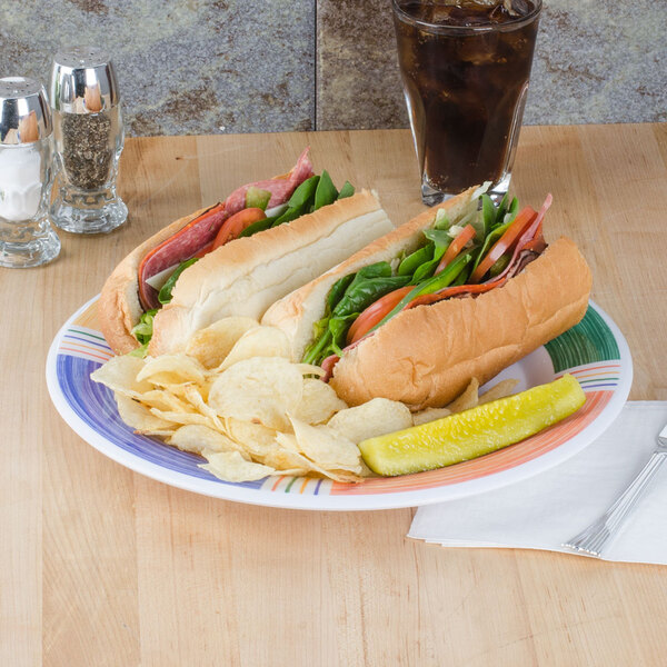 A GET Diamond Barcelona wide rim melamine plate with a sandwich and chips on it on a table.