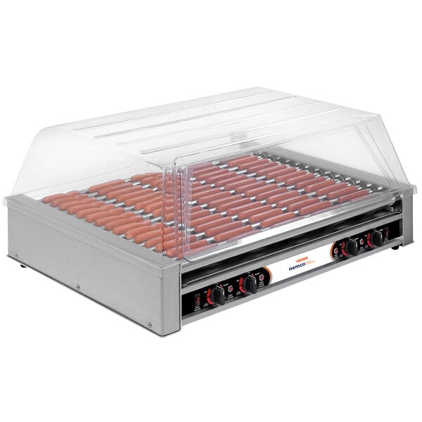 A Nemco hot dog roller grill with a clear cover filled with hot dogs.
