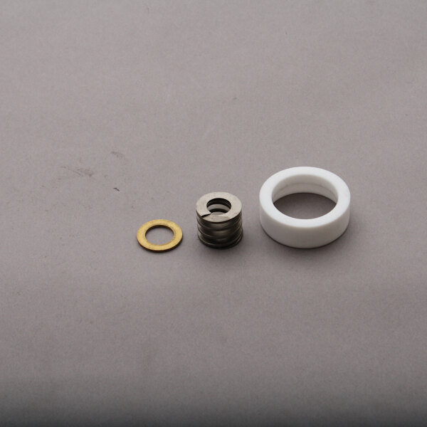 A white rubber seal and brass ring on a gray surface.