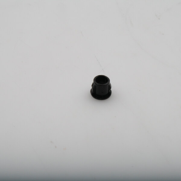 A black plastic bushing on a white surface.