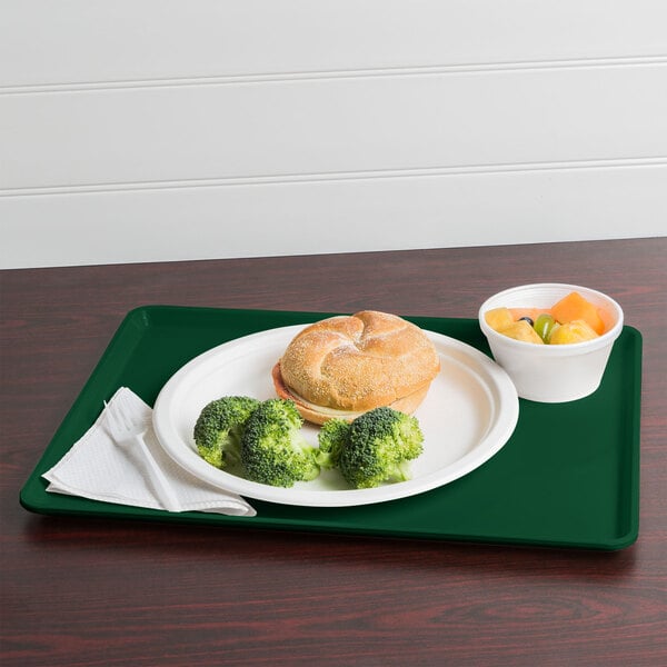 A Cambro Sherwood Green dietary tray with food including broccoli and soup on it.