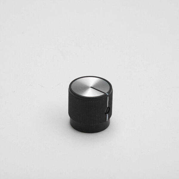 A black and silver Hatco heat control knob on a white surface.