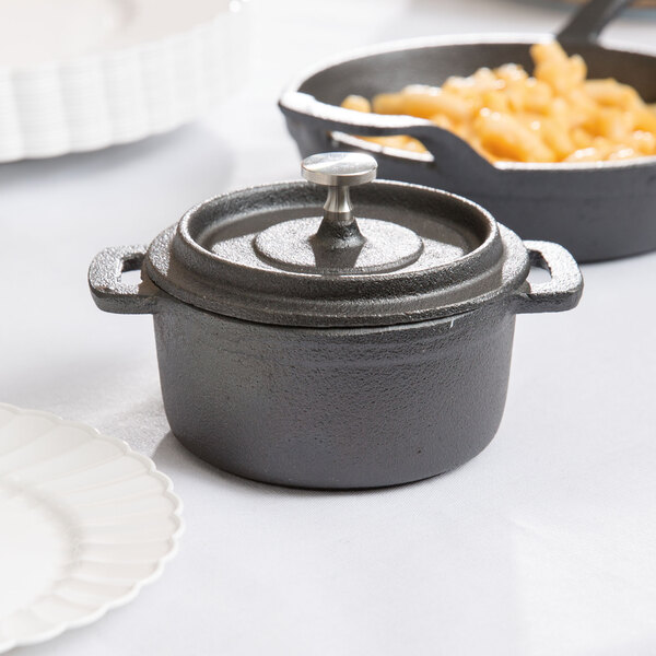 An American Metalcraft mini cast iron pot with macaroni and cheese and a lid.